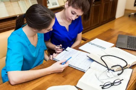 two nursing students at a table studying